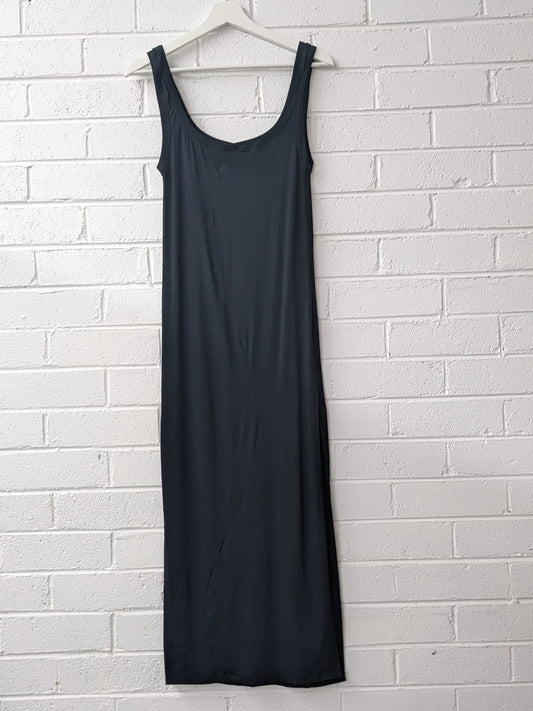 Black Bamboo Dress with Curved Design Lines on hanger against brick wall 